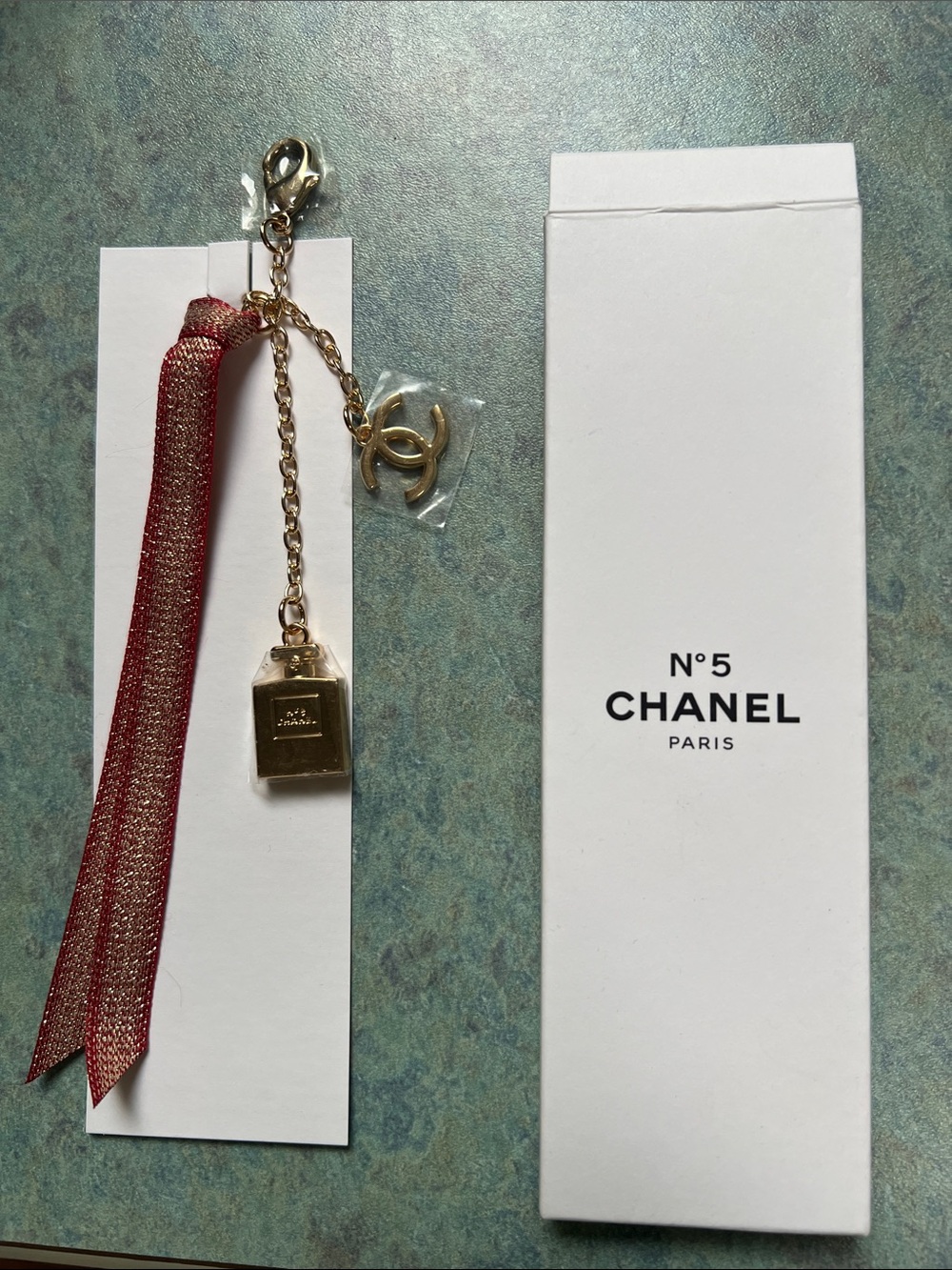 CHANEL Gold Perfume Bottle Charm with Red Ribbon Accent KEYCHAIN